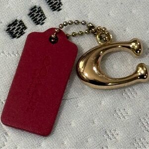 Coach Gold bag charm with the Iconic C and a Burgundy Leather Coach Tag New